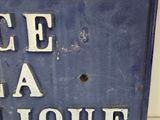 a blue sign with white writing on it on a wall