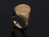 a gold signet ring with an image of a man ' s face on it