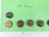 five different types of buttons on a green piece of paper