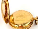 an image of a gold pocket watch sitting on a white surface