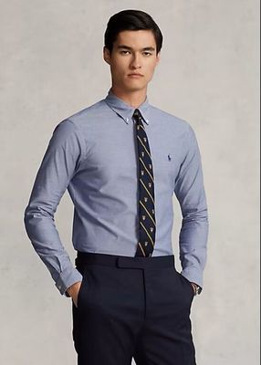 a man in a dress shirt and tie posing for a picture