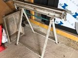 une photo d'un établi dans un garage où s'entassent toutes sortes de bric-à-brac