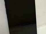 un téléphone portable noir posé sur une surface blanche