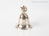 a silver bell with an angel on top of it