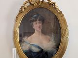 une photo d'une femme en robe bleue posée sur une cheminée
