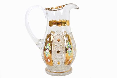 un pichet en verre transparent orné de motifs dorés