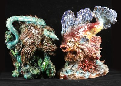 two figurines of a fish and a fish on a black background