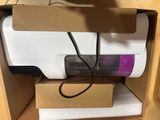 a white and purple vacuum in a cardboard box