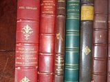 several old books are lined up on a wooden table