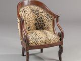 an antique chair with a leopard print upholstered seat