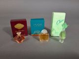Trois parfums différents sont posés les uns à côté des autres sur une table