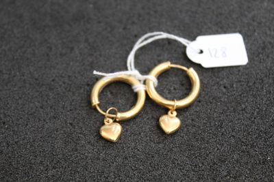 une paire de boucles d'oreilles créoles en or ornées de pendentifs en forme de cœur