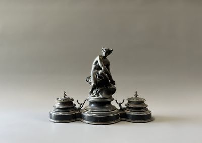 une statue de femme assise sur une table