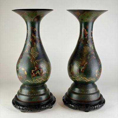 une paire de vases verts ornés de motifs sur fond blanc