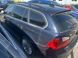 une voiture noire garée sur un parking, avec d'autres voitures en arrière-plan
