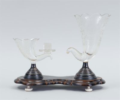 two clear glass vases sitting on top of a wooden stand