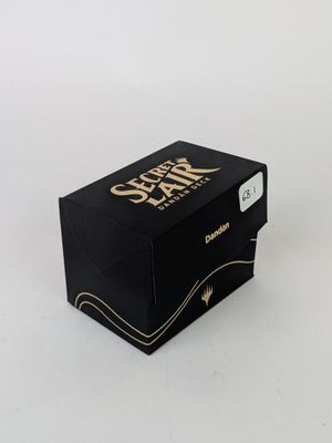 La boîte est noire et comporte un logo doré.