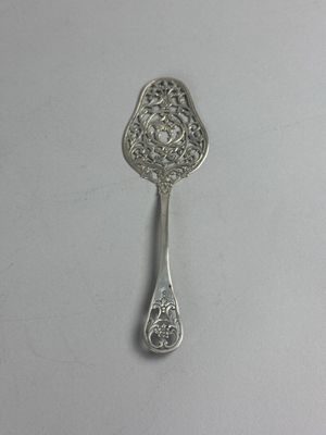 an antique silver spoon on a white surface with a silver handle