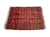 un vieux tapis rouge orné d'un motif en médaillon sur fond blanc