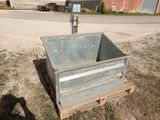 une caisse métallique posée sur une palette dans l'herbe