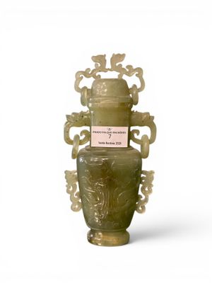 a green vase that is sitting on a white surface