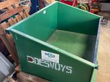 a green dumpster sitting on a pallet in a warehouse