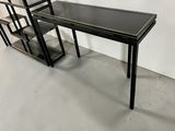 an image of a black desk with shelves and a book shelf