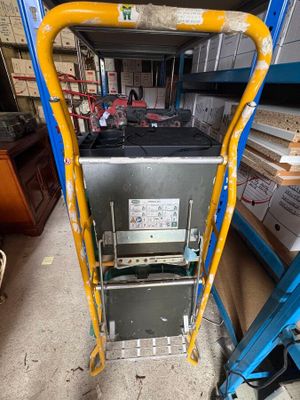 a close up of a ladder with a machine on it in a warehouse