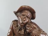bronze statue of a man with a hat on his head