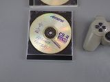 two cds and a video game controller on a table