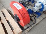 a red and white blower sitting on a pallet next to a wooden pallet
