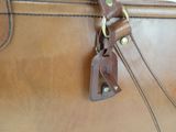 a close up of a brown leather bag with a handle