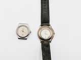 a close up of a wrist watch and a watch on a white surface