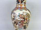 a vase with a painting on it sitting on a table