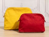 two red and yellow bags sitting on top of a wooden floor
