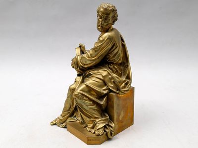 une photo représentant la statue d'un homme assis sur une caisse