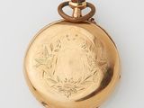 an image of a gold pocket watch with a floral design on it