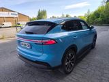 the rear end of a blue car parked in a parking lot