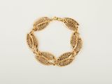 un bracelet en or orné d'un motif de feuilles