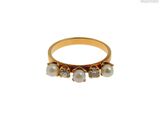 Gros plan sur une bague en or ornée de perles