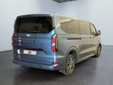 the rear of a blue van is parked in a large room