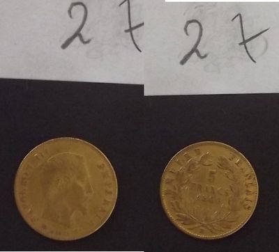 deux pièces d'or posées l'une à côté de l'autre sur une feuille de papier