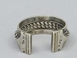 sterling silver ring with braided edges on a plain surface