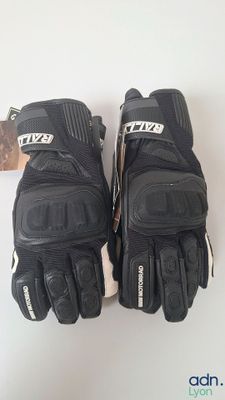 two pairs of black motorcycle gloves sitting on top of a white table