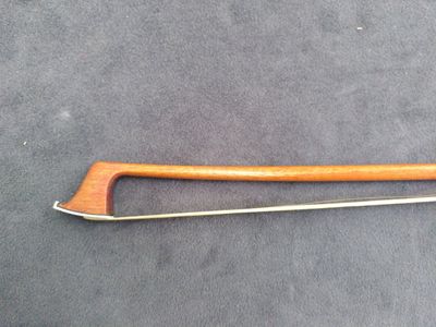 an image of a wooden and metal tool on a gray surface