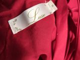 the label of a red dress is on the back of a red dress