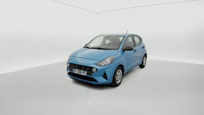 La petite voiture bleue est garée dans une pièce blanche.