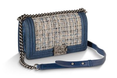un sac à main bleu et blanc muni d'une bandoulière en chaîne, sur fond blanc