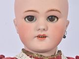 a close up of a doll with a red dress on