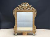 un miroir ancien avec un cadre doré et un socle en bois